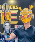 Bumblebee arm blaster and helmet worn in front of a Transformers display