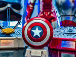 Captain America shield speaker on a shelf beside other Marvel collectibles