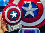Mini Captain America shield speaker held in front of a full-size shield